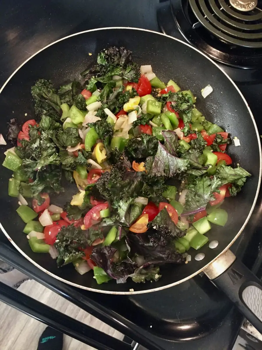 peppers, onions, tomatoes, red kale cooking in a pan