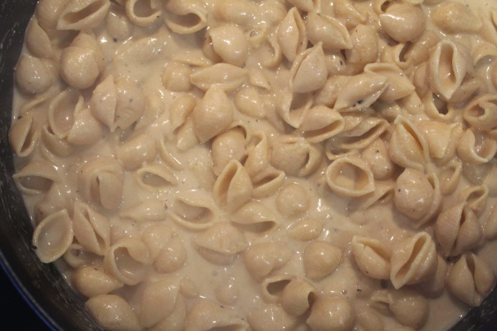 vegan alfredo pasta shells cooking on the stove